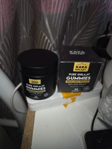 Customer's XARA SHILAJIT Pure Shilajit Gummies black jar and matching packaging box on a surface.