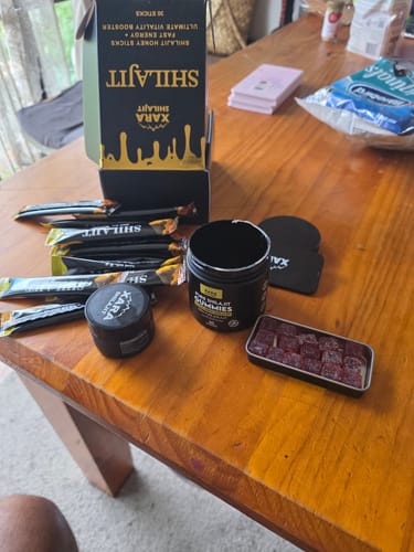 Customer's various XARA SHILAJIT products, including the Pure Shilajit Gummies in a jar and an open tin on a table.