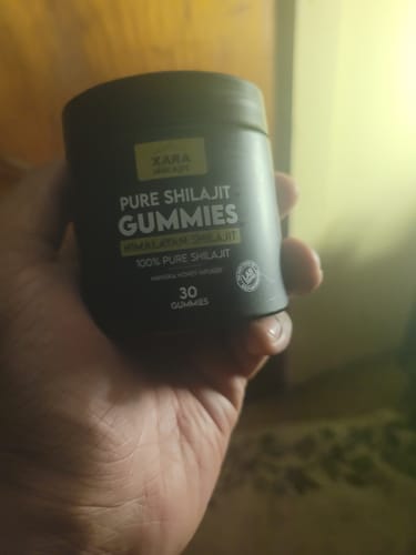 Customer holding the black container of XARA SHILAJIT® Pure Shilajit Gummies.