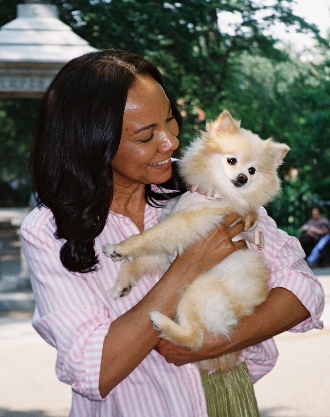 Woman holding a small fluffy dog outdoors